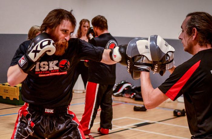 Adults working pads in an ISK Martial Arts kickboxing class